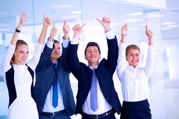 Feliz equipo de negocios mostrando pulgares hacia arriba en la oficina —  Fotos de Stock