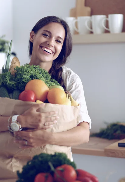 Ung kvinna med livsmedelsbutiker shoppingväska med grönsaker och frukt — Stockfoto