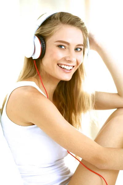 Portrait of beautiful woman in morning listening music sitting on bed at home — Stock Photo, Image