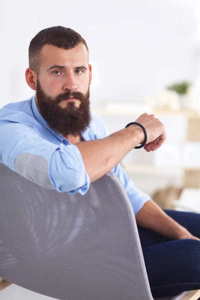 Young businessman sitting on chair in office — Stock Photo, Image