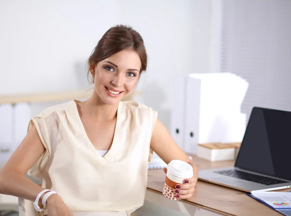 Schöne Geschäftsfrau genießt Kaffee im hellen Büro — Stockfoto