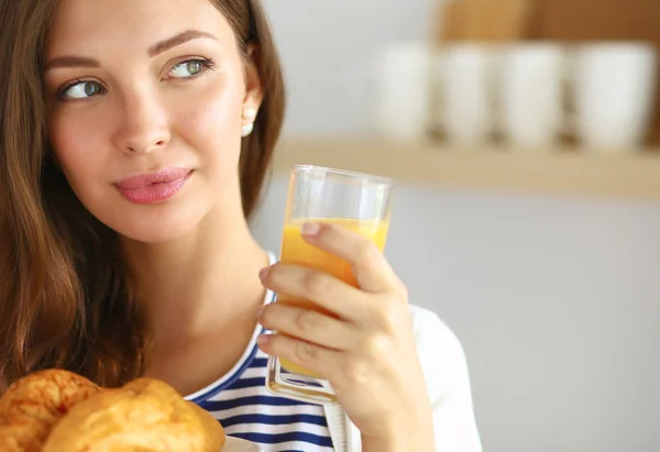 Jeune femme avec un verre de jus et des gâteaux — Photo