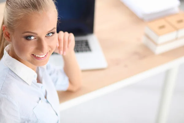 Attraente donna d'affari seduta su una scrivania con computer portatile in ufficio — Foto Stock