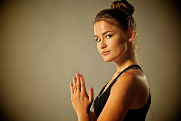 Ung kvinna gör yoga övning på grå bakgrund — Stockfoto