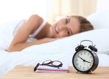 Kadın uyuyamıyorum. Masanın üzerinde saat