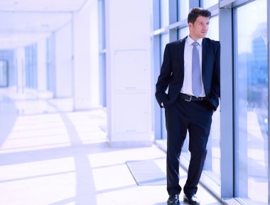 Ofisteki pencerenin yanında duran işadamının portresi