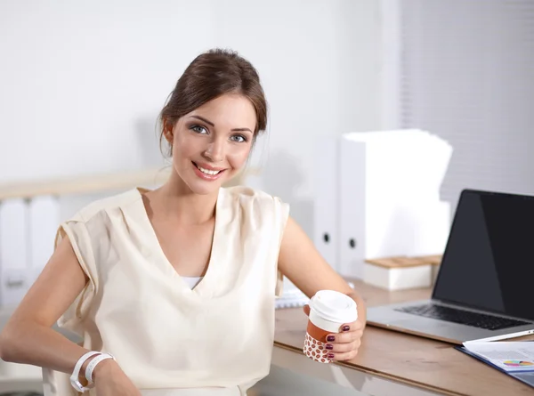 Schöne Geschäftsfrau genießt Kaffee im hellen Büro — Stockfoto