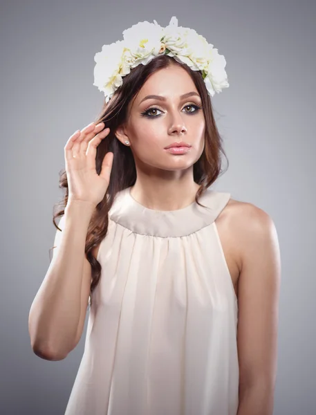 Retrato de uma mulher bonita com flores no cabelo. Moda — Fotografia de Stock