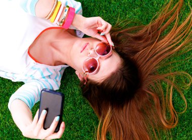 güzel ve genç birbayan yeşil çim yalan onu telefonla selfie yapma