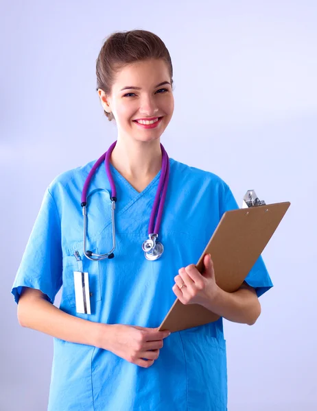 Médico sonriente con una carpeta en uniforme de pie en el hospital — Foto de Stock