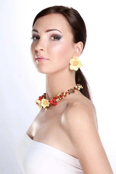 Portrait of young beautiful brunette woman in beads — Stock Photo, Image