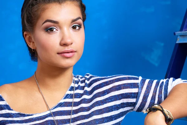 Happy beautiful young woman doing wall painting, standing near ladder — Stock Photo, Image