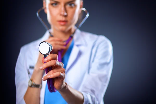 Female doctor with a stethoscope listening, isolated on grey background — Stock Photo, Image