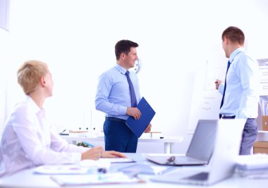 İş adamları iş toplantısında, ofiste oturup tartışıyorlar.