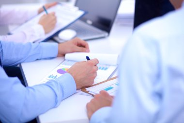 İş toplantılarında, ofiste oturan ve yazan iş adamları.