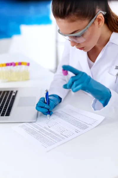 Woman researcher is surrounded by medical vials and flasks, isolated on white background — Stock Photo, Image