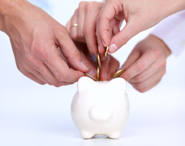 Люди кладут монеты в копилку
