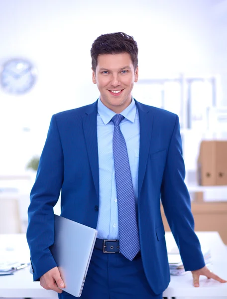 Business man or manager standing against his desk at the office — Stock Photo, Image