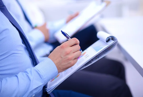 Zakenmensen zitten en schrijven op zakelijke bijeenkomst, in functie — Stockfoto