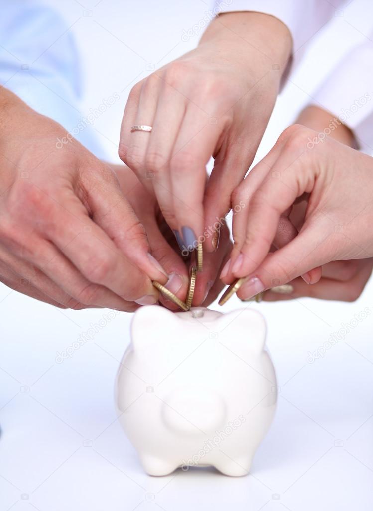 People putting coin into the piggy bank