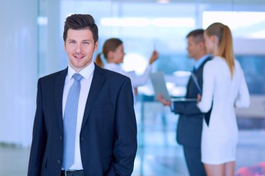 arka planda meslektaşları ile Office genç işadamı portresi
