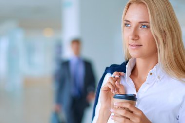 Yound kadın ayakta ofisindeki kahve içmek