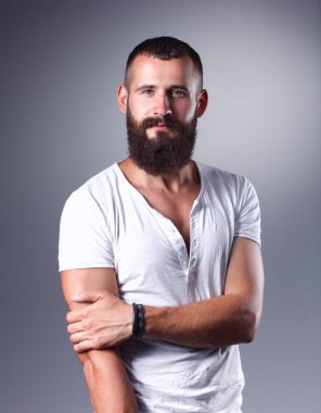ayakta, gri arka plan üzerinde izole yakışıklı sakallı adam portresi