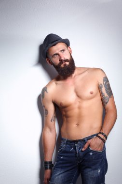 şapka ayakta, gri arka plan üzerinde izole yakışıklı sakallı adam portresi