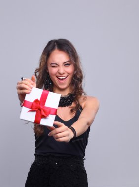 genç kadın mutlu gülümseme hediye kutusu gri arka plan üzerinde izole elinde tut