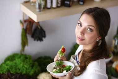 Salata yemek ve karışık salata tutan genç kadın