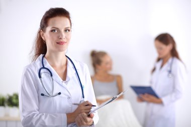 Hastanede üniformalı, gülümseyen bir kadın doktor.