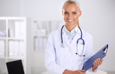 Hastanede üniformalı, gülümseyen bir kadın doktor.