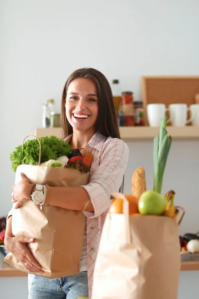 Jeune femme tenant sac d'épicerie avec des légumes — Photo