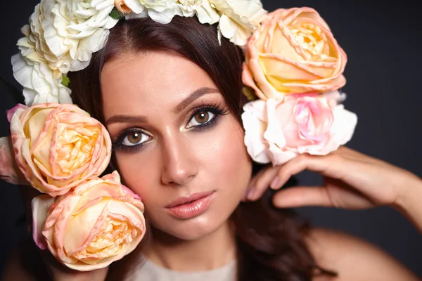 Retrato de uma mulher bonita com flores no cabelo. Moda — Fotografia de Stock