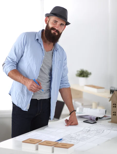 Retrato de diseñador masculino en sombrero con planos en el escritorio —  Fotos de Stock
