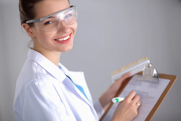 Leende kvinnlig läkare med en mapp i uniform stående på sjukhus — Stockfoto