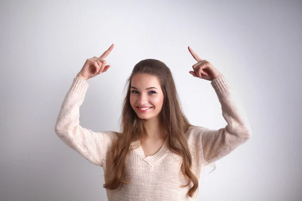 Retrato de una joven sonriente señalando hacia arriba, de pie —  Fotos de Stock