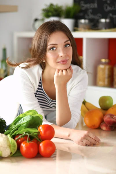 Young woman sitting near desk in the kitchen — Stock Photo, Image