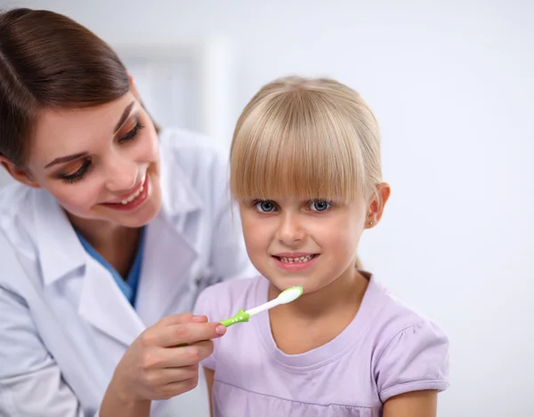 Tandlæge og lille pige i tandlægen kontor - Stock-foto