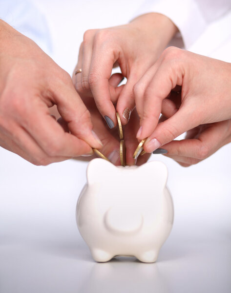 Люди кладут монеты в копилку
