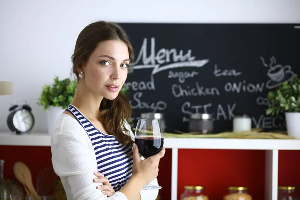 Mooie vrouw die thuis wat wijn drinkt in de keuken — Stockfoto