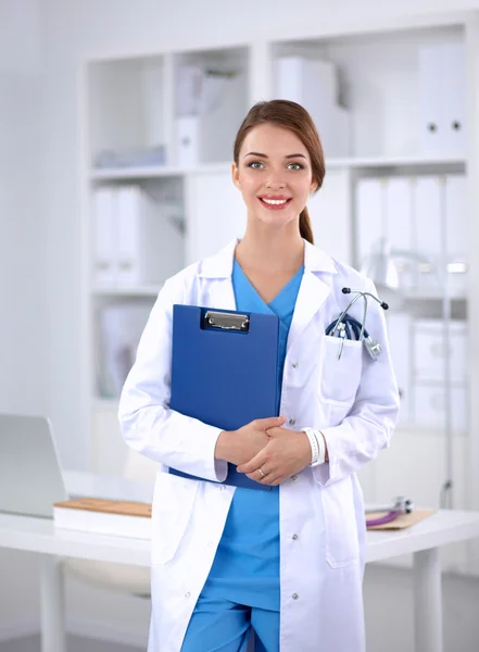 Portrait of young woman doctor with white coat standing in hospital — Stock Photo, Image