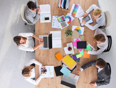 İş adamları iş toplantısında, ofiste oturup tartışıyorlar.