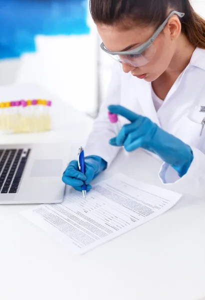 Vrouwelijke onderzoeker is omringd door medische flacons en flacons, geïsoleerd op witte achtergrond — Stockfoto