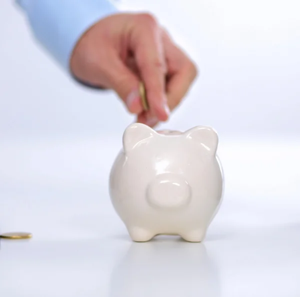 People putting coin into the piggy bank — Stock Photo, Image