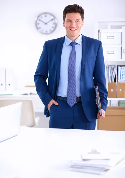 Homme d'affaires ou directeur debout contre son bureau au bureau — Photo