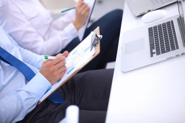 Zakenmensen zitten en schrijven op zakelijke bijeenkomst, in functie — Stockfoto