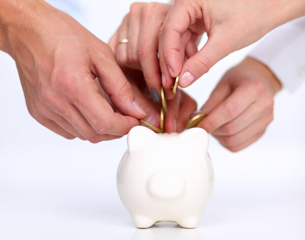 People putting coin into the piggy bank