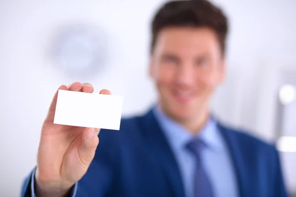 Retrato de un joven sosteniendo una tarjeta blanca en blanco — Foto de Stock