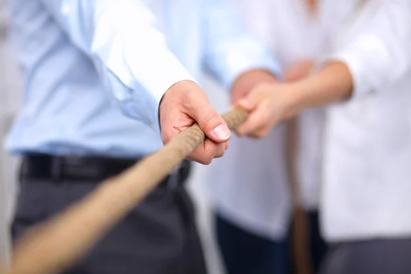 Konzeptbild eines Geschäftsteams, das ein Seil als Element der Teamarbeit im Vordergrund verwendet — Stockfoto